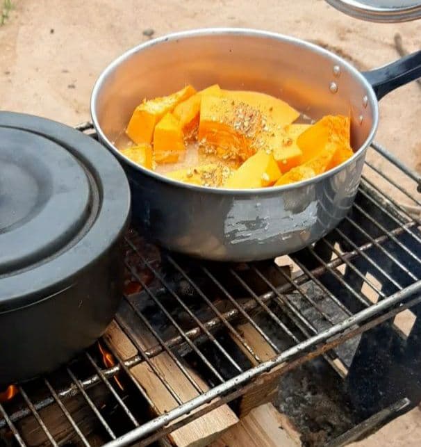 Panela com abóbora cozinhando no fogão à lenha